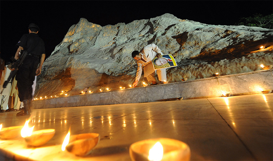 An activist lit lamps on May 27, 2008 in Islamabad in front of a replica of the Chaghi mountain where Pakistan's first nuclear test was conducted on 28 May 1998. (AFP/FILE)