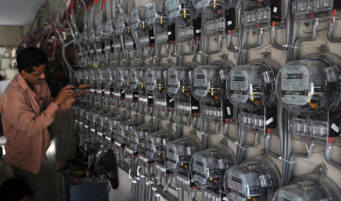 A technician from the Karachi Electric Supply Corporation (KESC) fixes new electricity meters at a residential building in Karachi, Pakistan, on May 13, 2010. (AFP/File)