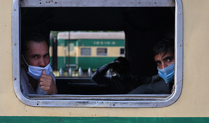 Passengers wearing facemasks look out from a window of a train as they are going to their hometown, Rawalpindi Pakistan May 11, 2021. (AFP/FILE)