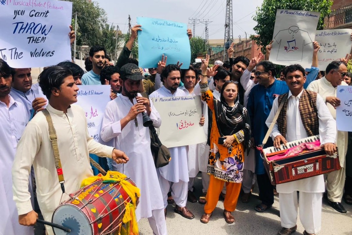 Pakistani musicians and civil society members protest the arrest of Afghan singers by playing a drum and a harmonium in Peshawar, Pakistan, on May 30, 2022. (AN Photo)