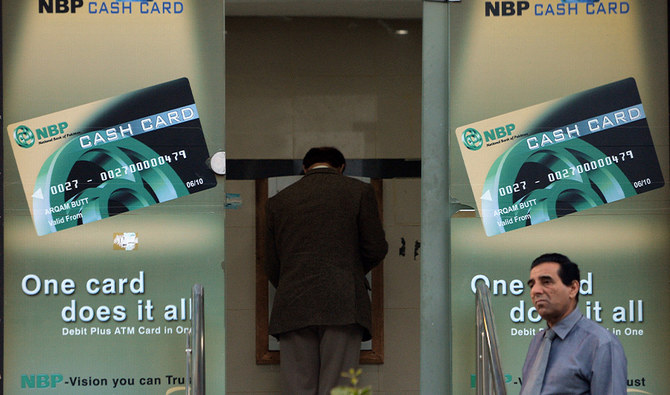 This photograph taken on March 4, 2015 shows a Pakistani resident waiting to withdraw currency from an ATM in Islamabad. (AFP/File)