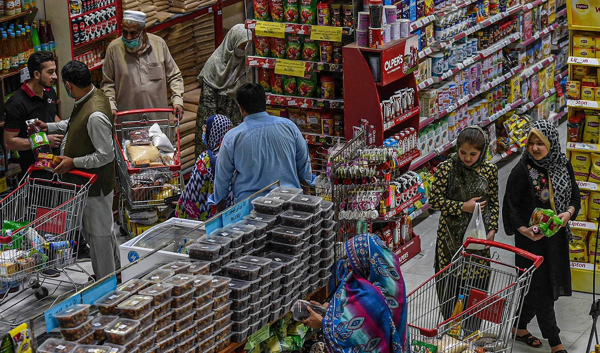 People buy grocery items at a store in Peshawar, Pakistan, on April 5, 2021. (AFP/File)
