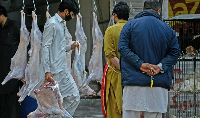 A butcher wearing a facemask carries goat meat at a market in Islamabad, Pakistan, on April 9, 2020. (AFP/File)