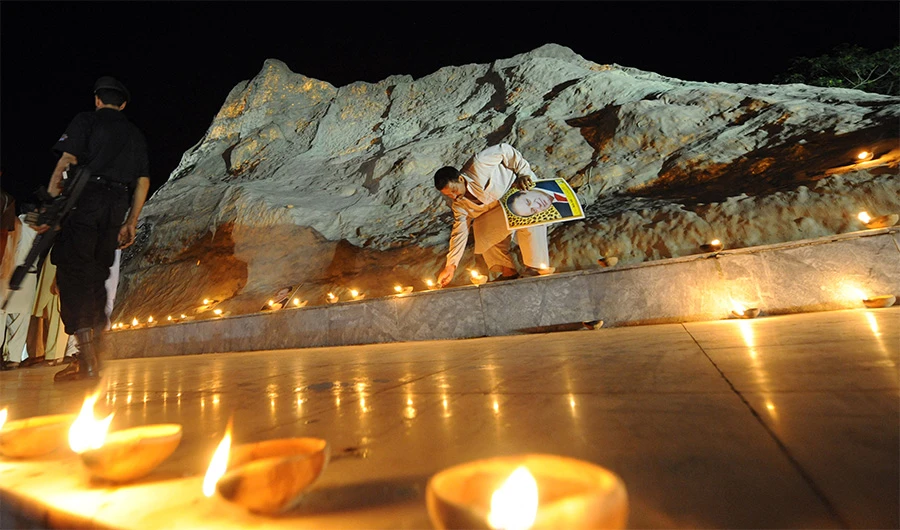 An activist lit lamps on May 27, 2008 in Islamabad in front of a replica of the Chaghi mountain where Pakistan's first nuclear test was conducted on 28 May 1998. (AFP/FILE)