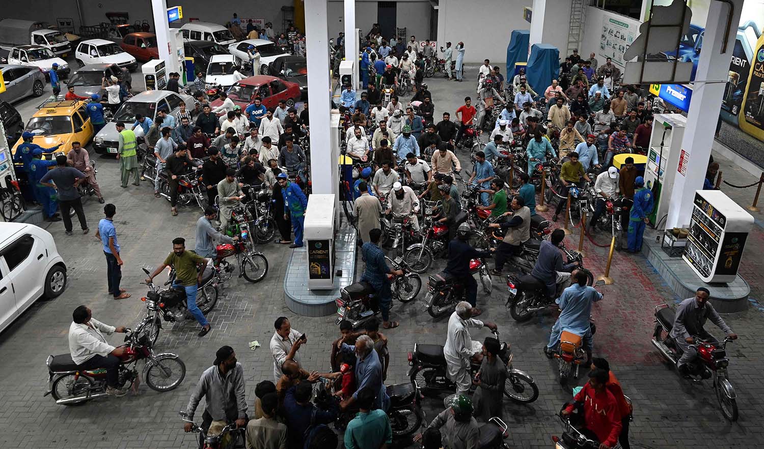 Motorists wait to fill their vehicles' tanks at a petrol station in Islamabad on June 2, 2022, following an increase of petroleum prices by the government. (AFP)