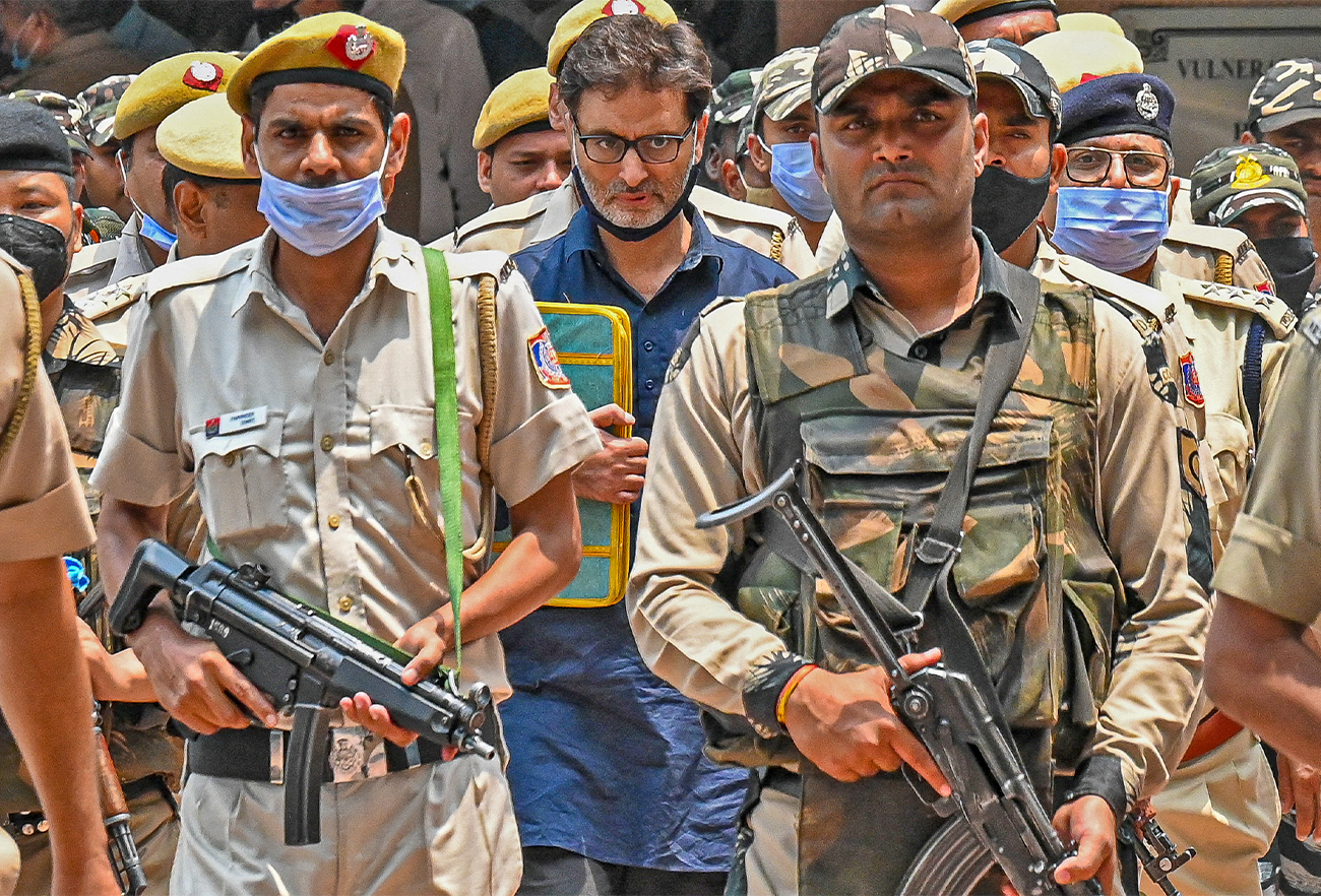 Police and security personnel escort pro-independence party Jammu Kashmir Liberation Front chairman Yasin Malik (C) to a holding area after a sentencing hearing at Patiala house court in New Delhi on May 25, 2022. (AFP)