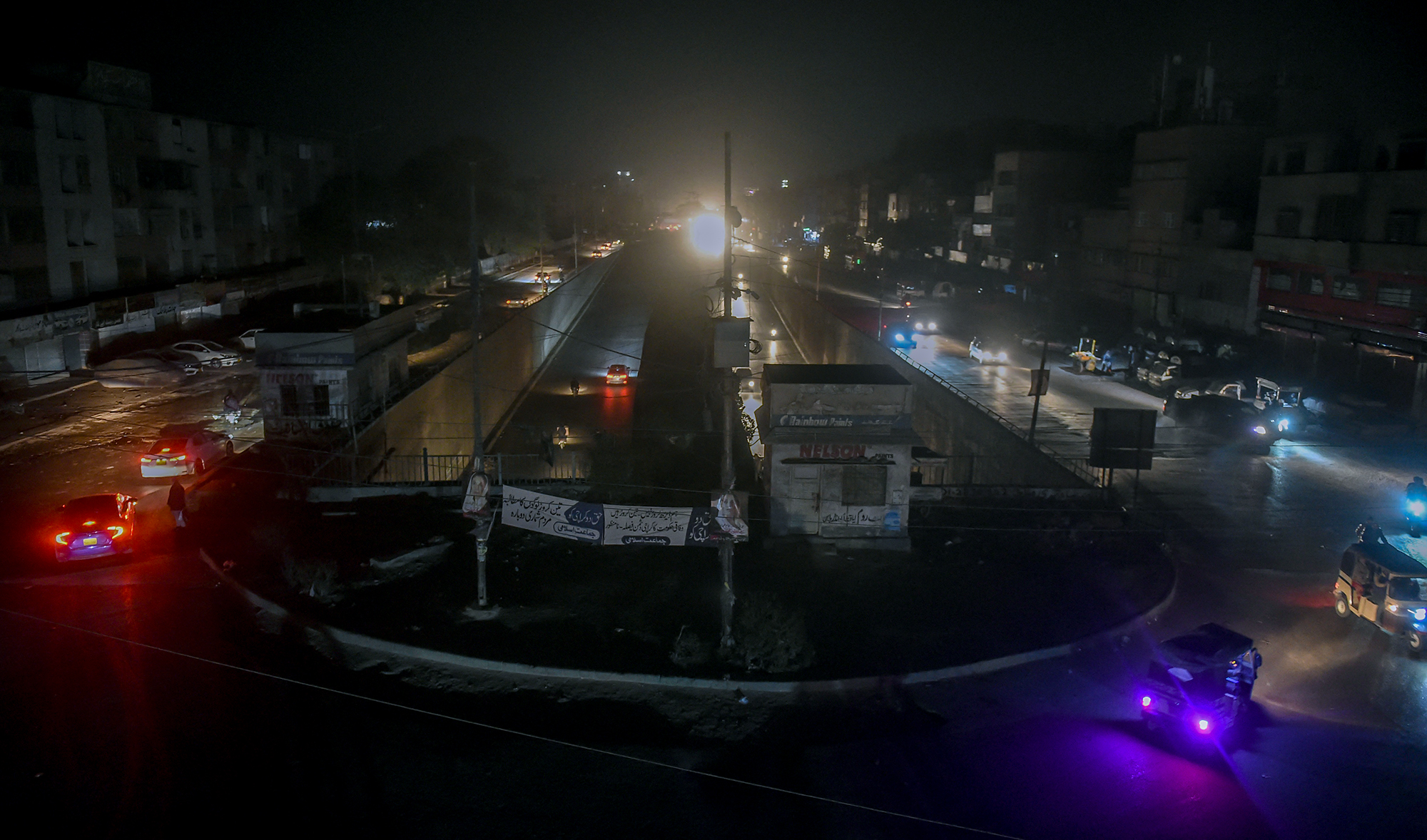 Motorists drive through a residential area during a power blackout in Pakistan's port city of Karachi early on January 10, 2021. (AFP/File)