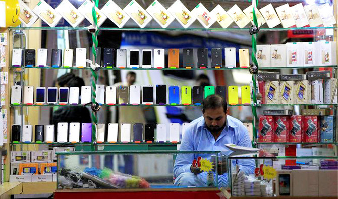 A shopkeeper plays with his mobile phone at a phone market in Rawalpindi, Pakistan, on July 4, 2017. (REUTERS/File)