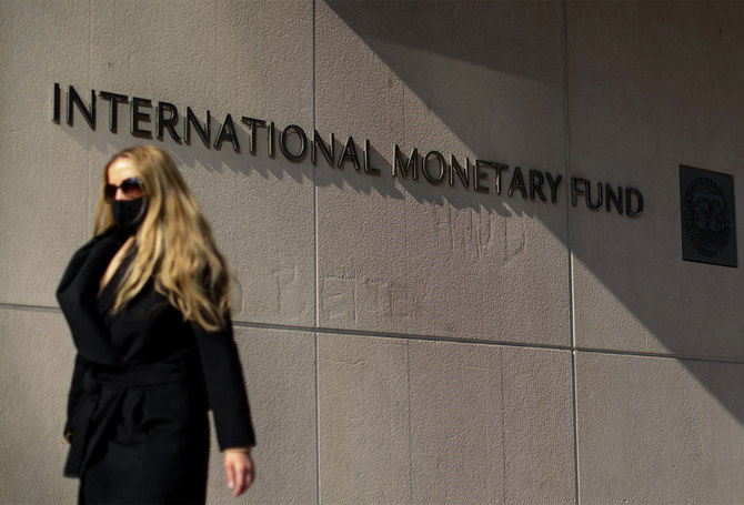 A woman walks past an International Monetary Fund headquarters (IMF) building in Washington, USA, on April 5, 2021. (AFP/File)