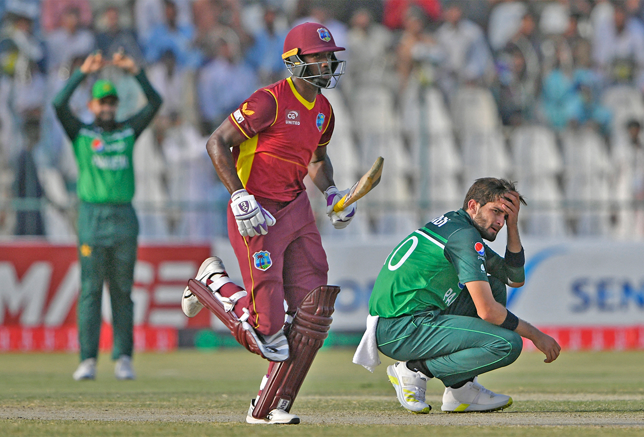 Pakistan's Shaheen Shah Afridi (R) reacts as West Indies' Shamarh Brooks (C) runs between the wickets during the first one-day ODI cricket match in Multan, Pakistan, on June 8, 2022. (AFp)