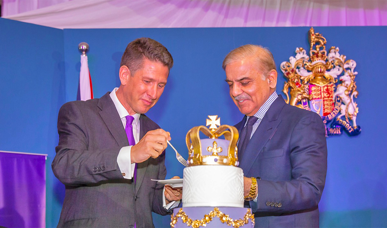 Pakistan Prime Minister Shehbaz Sharif and British High Commissioner to Pakistan Christian Turner cut a cake in Islamabad, Pakistan, on June 8, 2022. (@CTurnerFCDO/Twitter)
