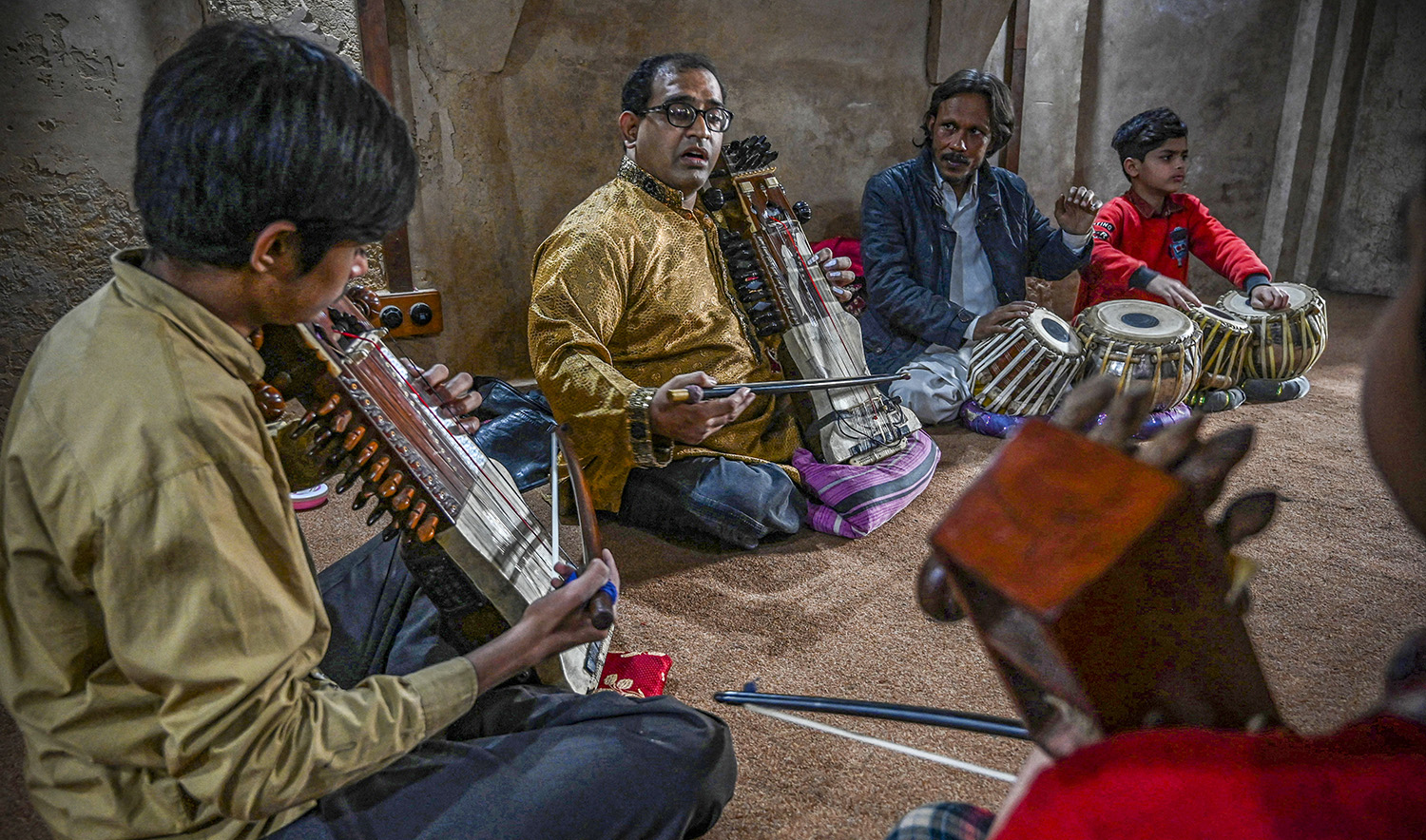 In this picture taken on February 24, 2022, Zohaib Hassan (C) teaches his students to play sarangi at his academy in Lahore. (AFP/File)