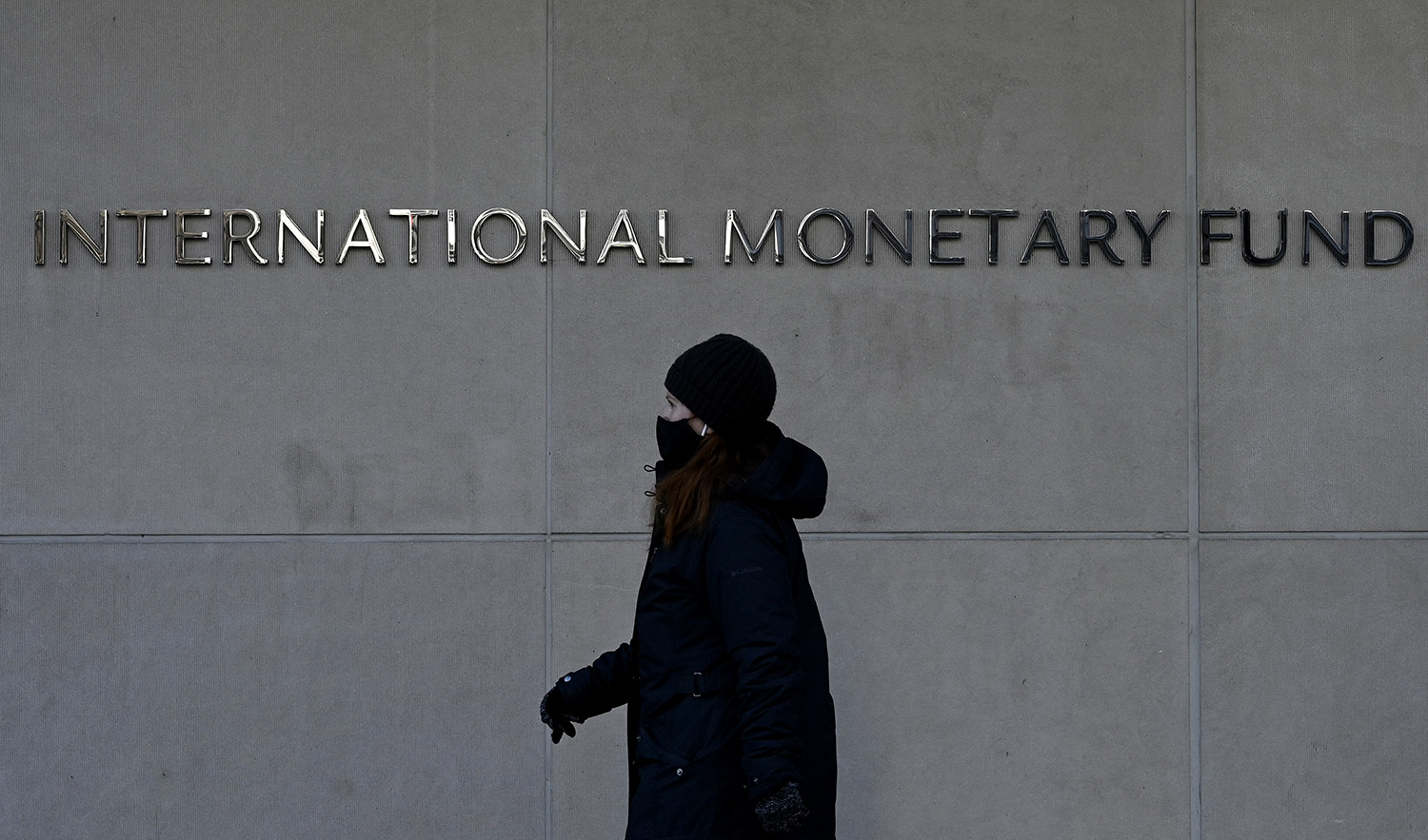 In this file photo taken on January 26, 2022, a woman walks past the International Monetary Fund headquarters in Washington, DC. (AFP/File)