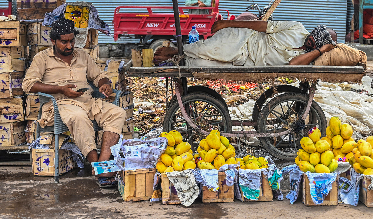 Vendors wait for customers at a fruit market in Islamabad, Pakistan, on July 12, 2021. (AFP/File)