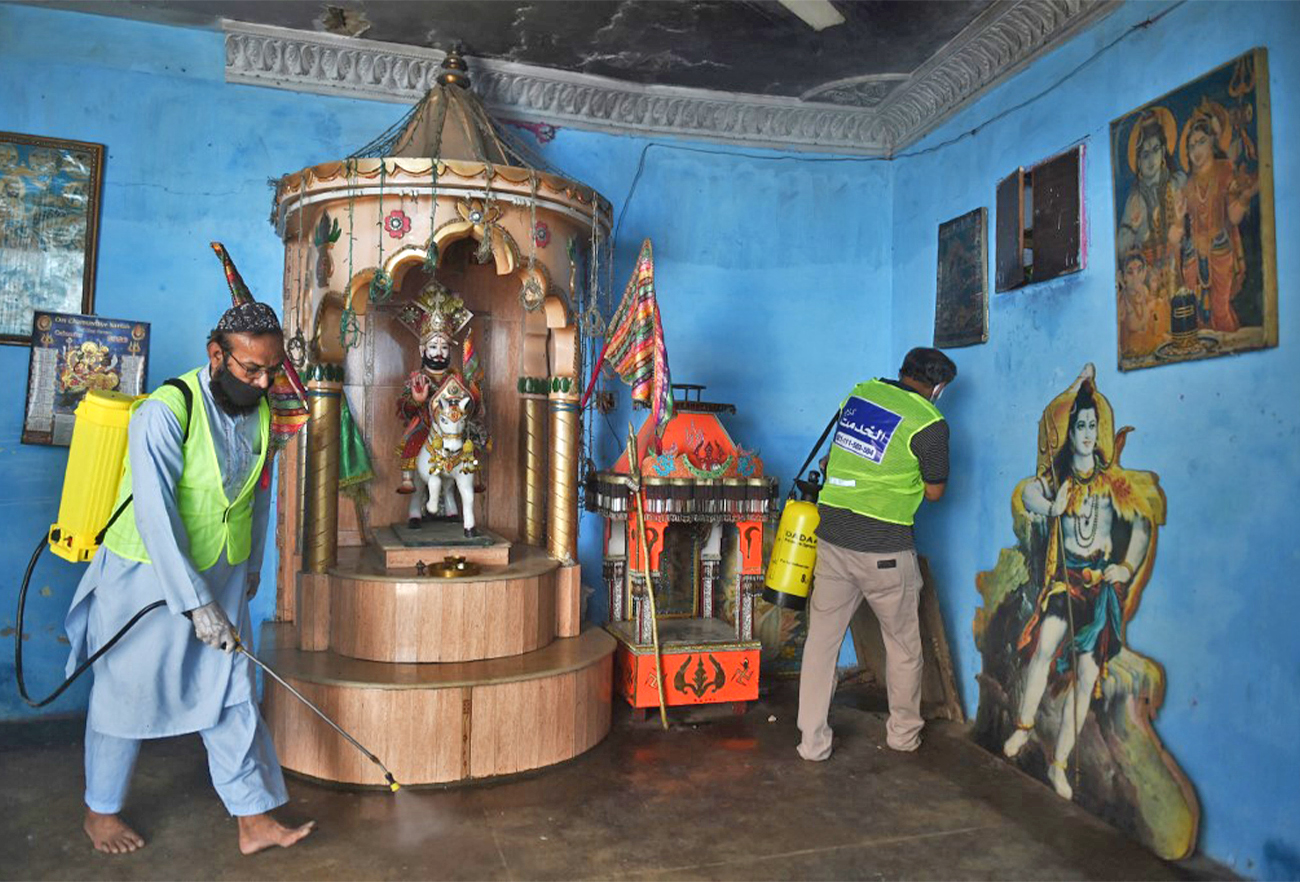 Workers spray disinfectant at a Hindu temple in Karachi, Pakistan, on March 30, 2020. (AFP/File)