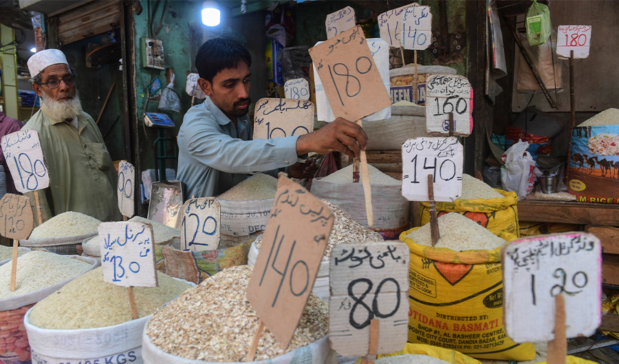 A shopkeeper place a price tag on rice at a shop in Karachi on June 10, 2022. (AFP)
