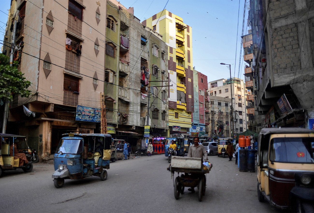 In this picture taken March 9, 2022, people and vehicles make their way along a street in the Lyari district of Karachi, Pakistan. (AFP)