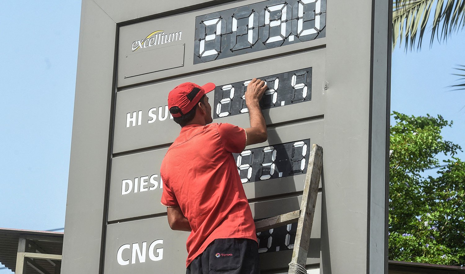 An employee of a petrol station updates the latests fuel prices on a board in Karachi on June 16, 2022, after a hike in prices of petroleum products by the government. (AFP/File)