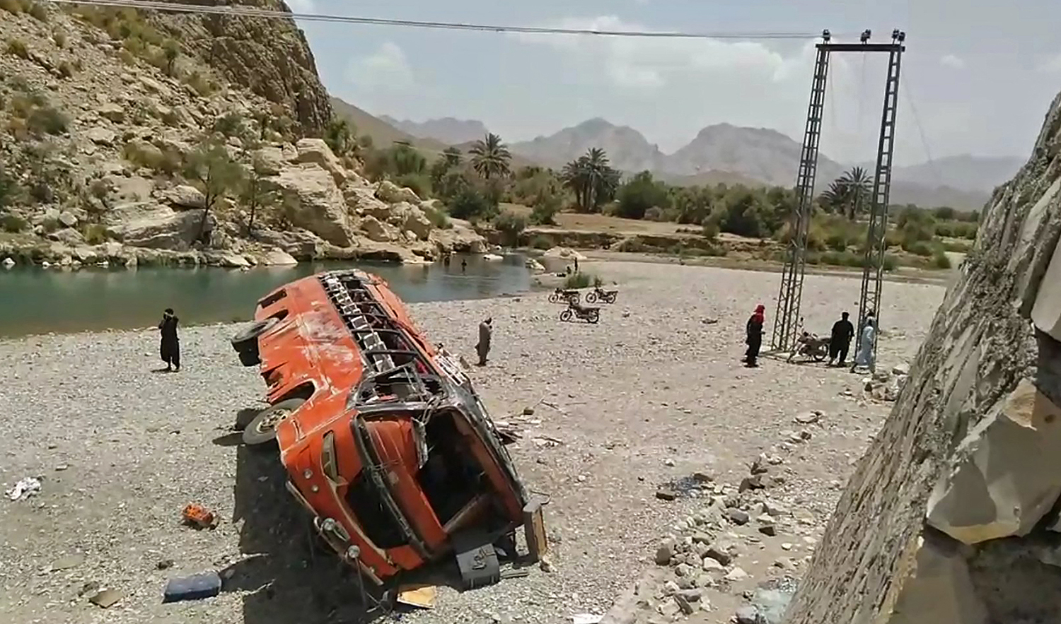In this representational photo, onlookers stand next to a damaged bus at the site of an accident in a remote district of Balochistan province on June 11, 2021. (AFP/File)