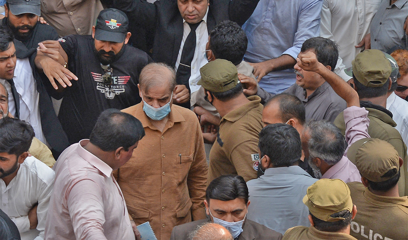 Security officials escort Pakistan Prime Minister Shehbaz Sharif (C), as he leave the National Accountability Bureau court after a money-laundering case hearing, in Lahore on October 13, 2020. (AFP/File)