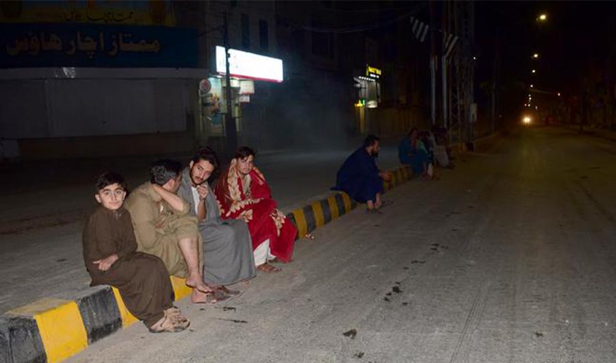 In this file photo, residents sit on the pavement outside their homes in the city of Quetta following the 5.7 magnitude earthquake on October 7, 2022.(AP/FILE)