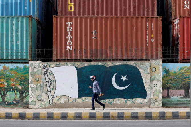 A man walks past a wall of a shipping container's yard painted with a national flag in Karachi, Pakistan August 6, 2018. (REUTERS/ File)