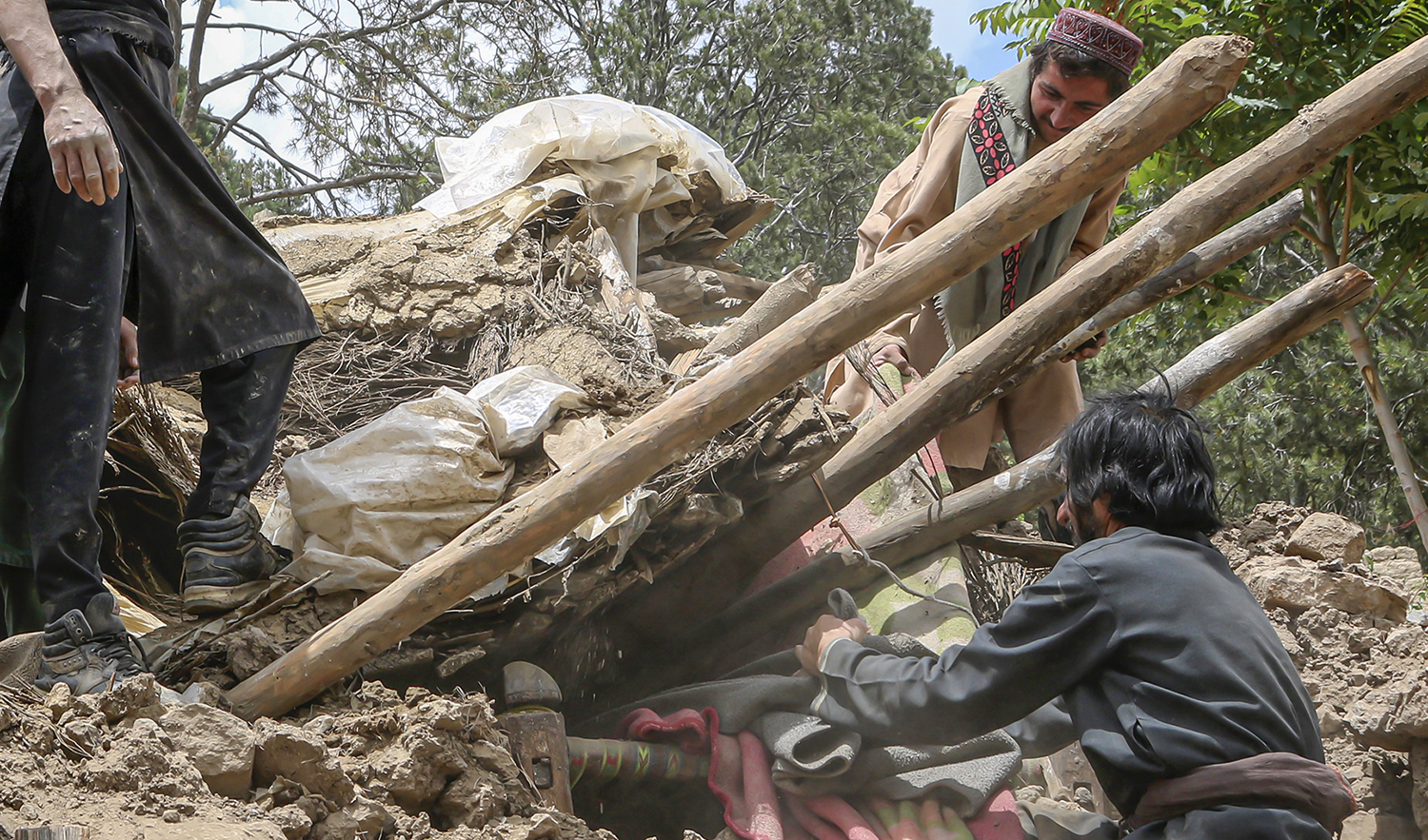 Afghan villagers collects belongings from under the rubble of a home that was destroyed in an earthquake in the Spera District of the southwestern part of Khost Province, Afghanistan, Wednesday, June 22, 2022. (AP)