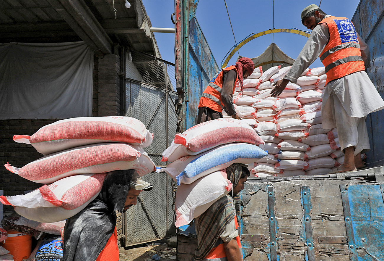 Volunteers from the Al-Khidmat Foundation load sacks of flour on a truck for the people affected by the earthquake in Afghanistan, in Peshawar, Pakistan, on June 23, 2022. (REUTERS)
