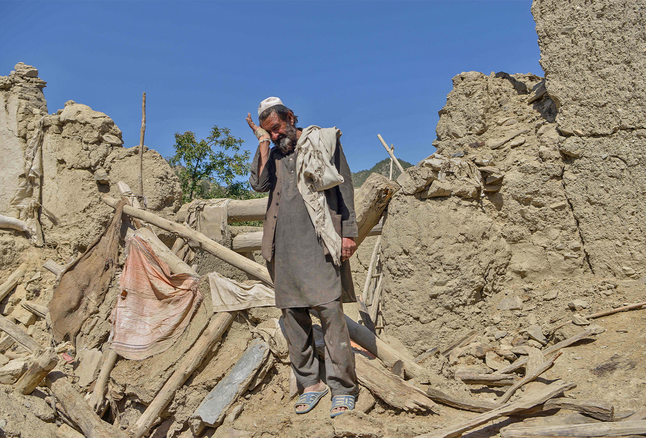 An Afghan man stands besides the ruins of a house damaged after an earthquake in Gayan district, Paktika province, on June 24, 2022. (AFP)