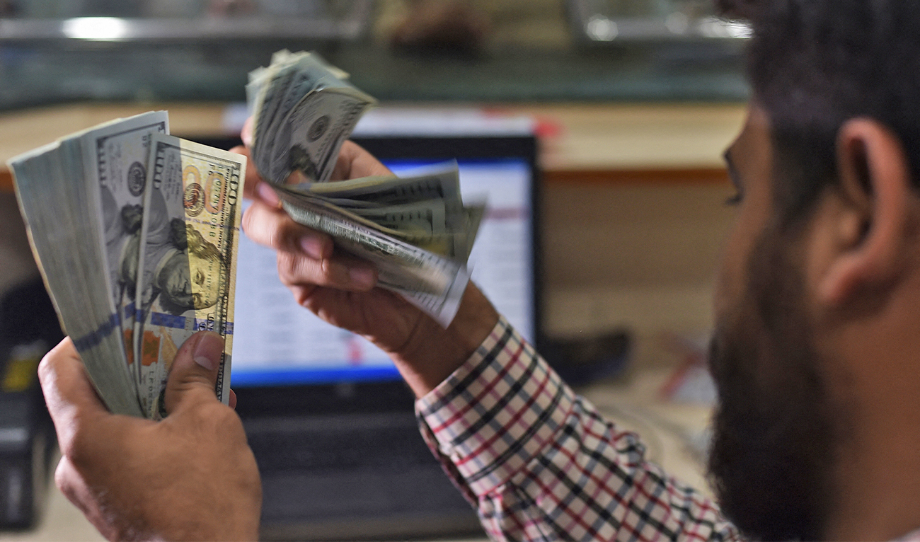 A Pakistani dealer counts US dollars at a currency exchange shop in Karachi, Pakistan, on October 9, 2018. (AFP/File)