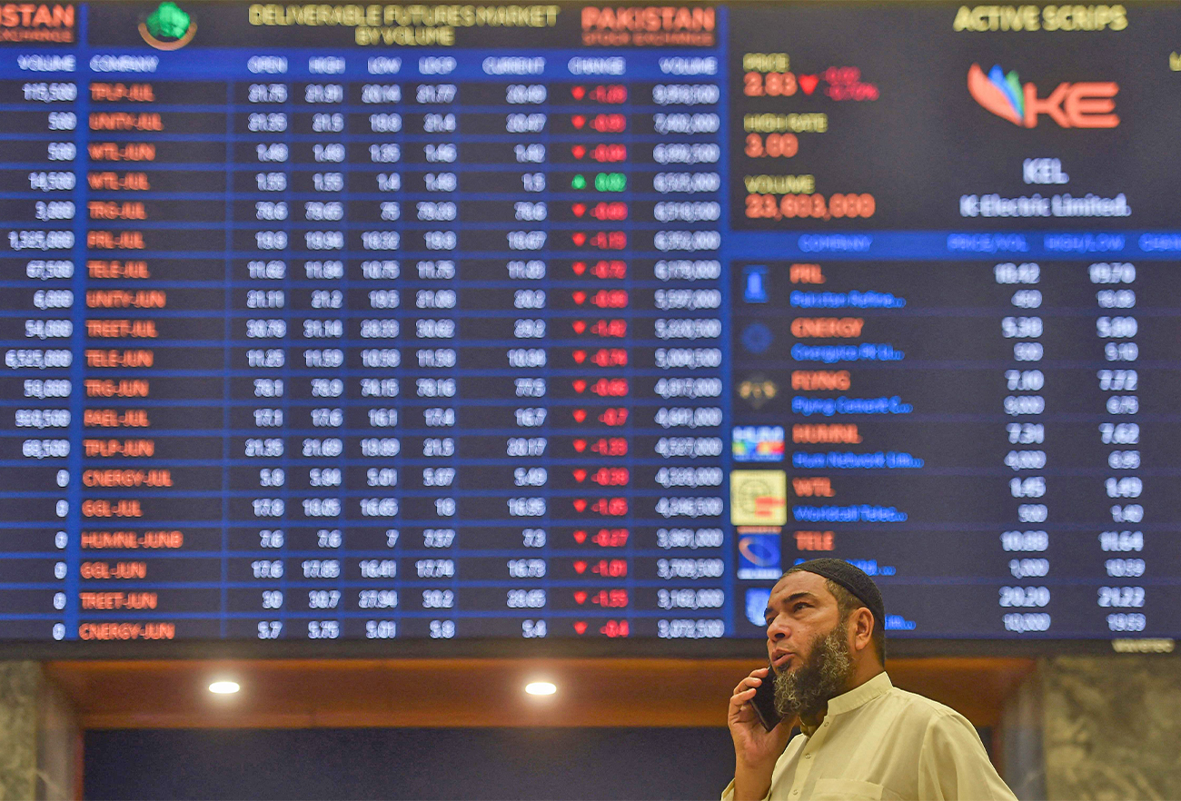 A stockbroker speaks on a phone while monitoring the share prices during a trading session at the Pakistan Stock Exchange (PSX) in Karachi on June 24, 2022. (AFP)