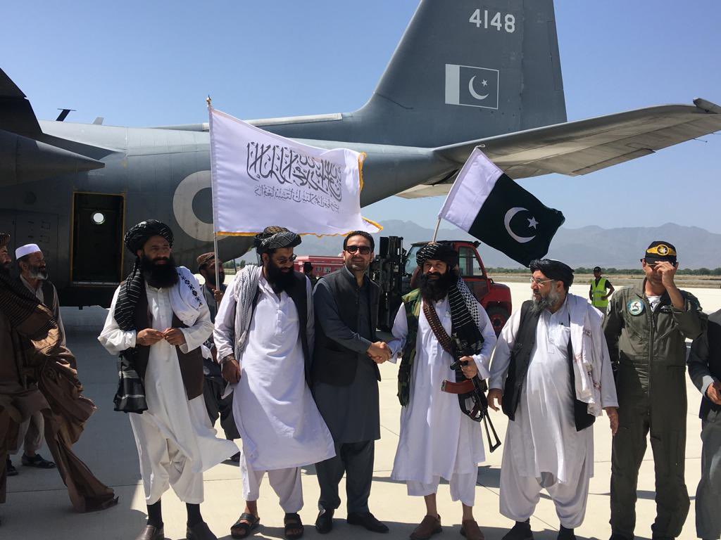Pakistan and Afghan Taliban officials pose for a photo in front of C-130, Pakistani aircraft carrying relief goods for Afghanistan's earthquake victims in Khost, Afghanistan on June 25, 2022. (@ambmansoorkhan/Twitter)