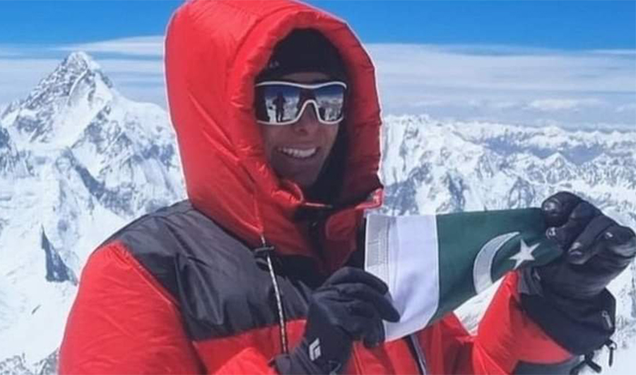 In this photo, Dubai-based Pakistani climber Naila Kiani holding a Pakistani flag pose for a photo at Mt. Gasherbrum II. (Social Media)