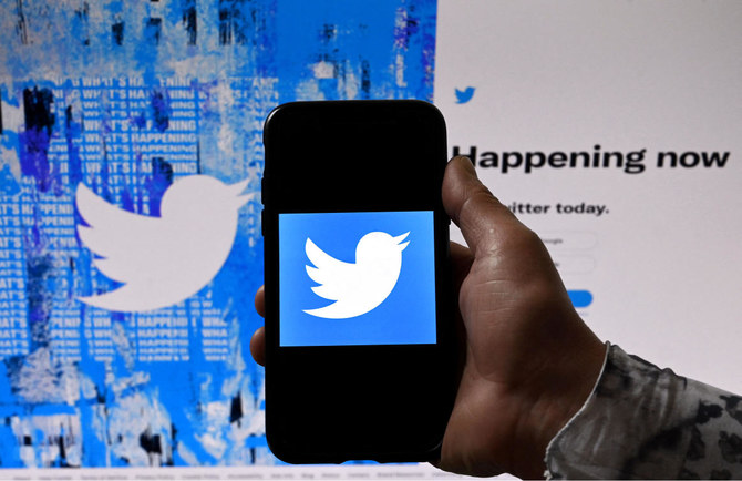 In this photo illustration, a phone screen displays the Twitter logo on a Twitter page background, in Washington. (AFP)