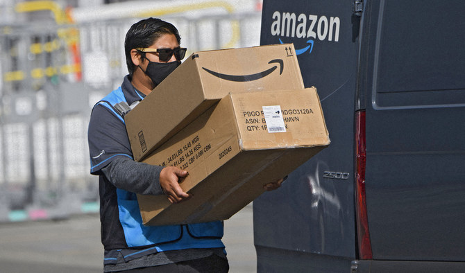An Amazon.com Inc. delivery driver carries boxes into a van outside of a distribution facility on February 2, 2021 in Hawthorne, California. (AFP/File)