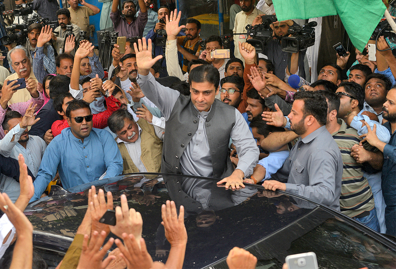 Hamza Shehbaz waves to supporters during the case hearing of his father and opposition leader Shahbaz Sharif in the corruption court in Lahore, Pakistan, on October 6, 2018. (AFP/File)
