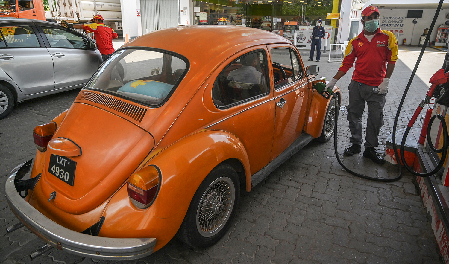 A petrol station worker wearing a face mask fills a vehicle's tank in Islamabad, Pakistan, on April 22, 2020. (AFP/File)