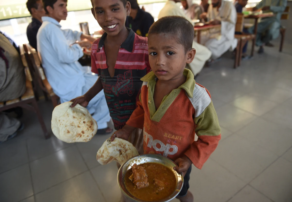 Pakistani boys carry their food at a free food distributing centre in Karachi on June 4, 2016. (AFP/FILE)