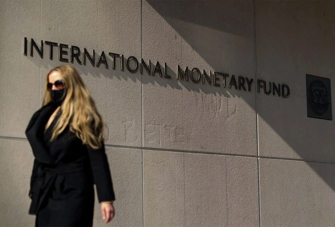 A woman walks past an International Monetary Fund headquarters (IMF) building in Washington, USA, on April 5, 2021. (AFP/File)