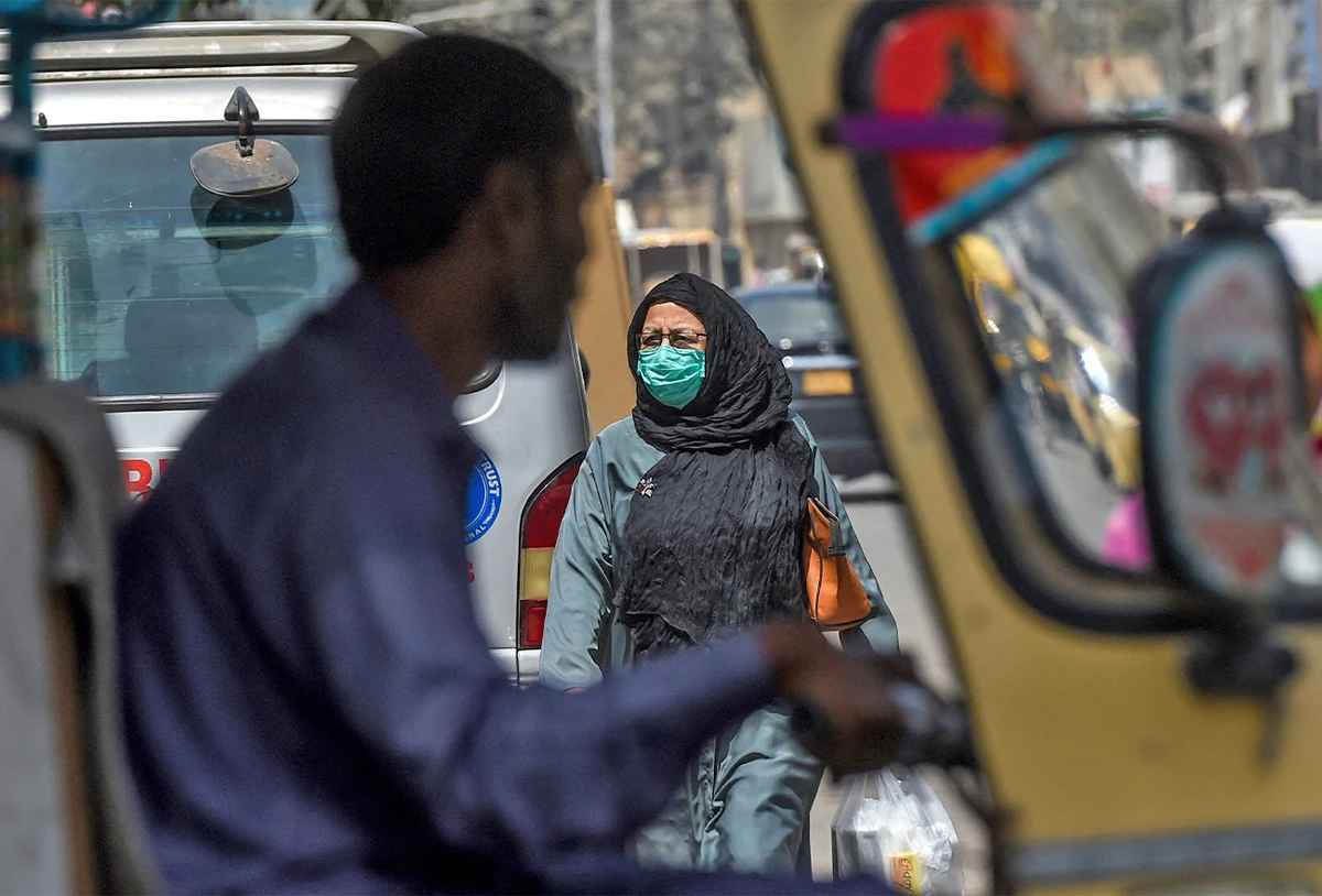 A woman crosses a road in Karachi on March 13, 2020. (AFP/File)
