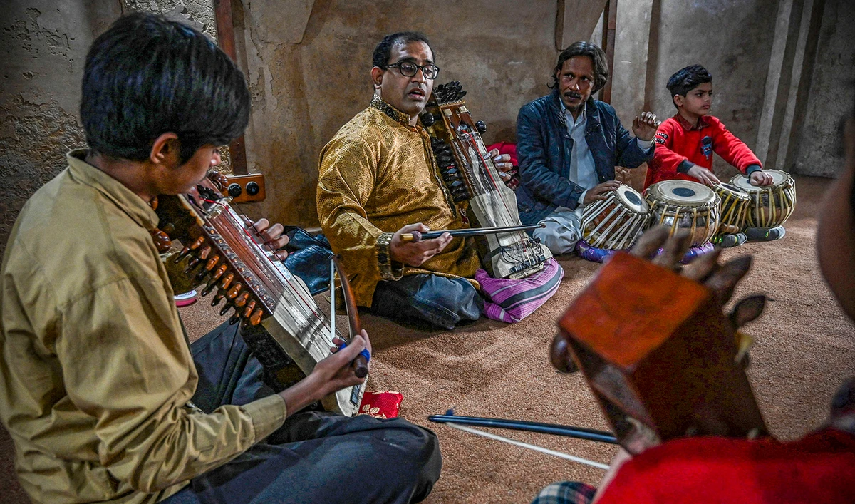 In this picture taken on February 24, 2022, Zohaib Hassan (C) teaches his students to play sarangi at his academy in Lahore. (AFP/File)