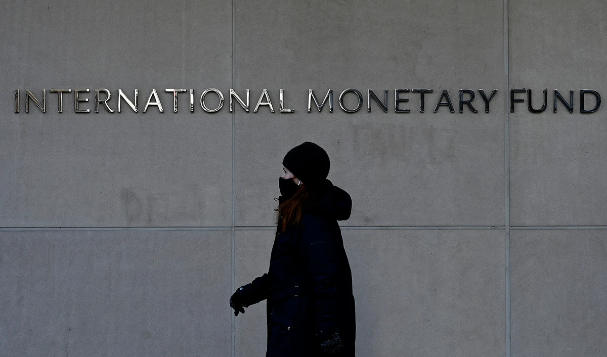 In this file photo taken on January 26, 2022, a woman walks past the International Monetary Fund headquarters in Washington, DC. (AFP/File)