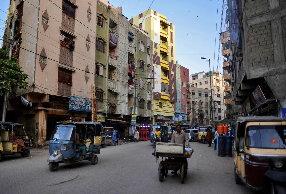 In this picture taken March 9, 2022, people and vehicles make their way along a street in the Lyari district of Karachi, Pakistan. (AFP)