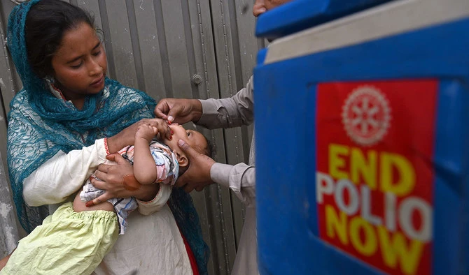 A health worker administers polio vaccine drops to a child during a door-to-door polio vaccination campaign at a slum area in Lahore on May 23, 2022. (AFP/File)