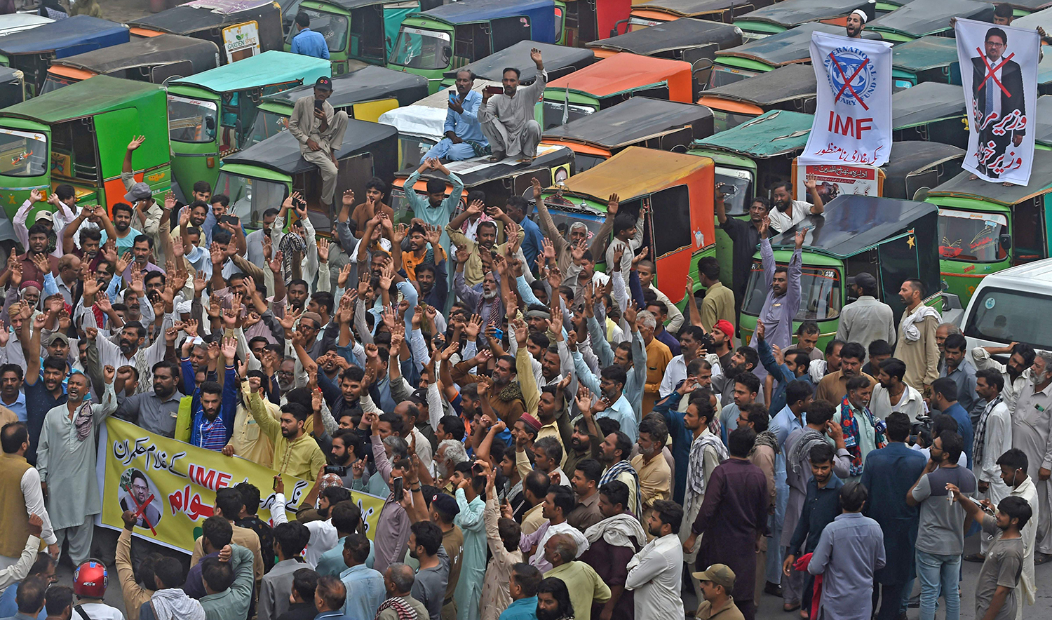 Autorickshaw drivers shout slogans as they protest against the rising fuel price during an anti-government demonstration in Lahore, Pakistan, on July 1, 2022. (AFP)