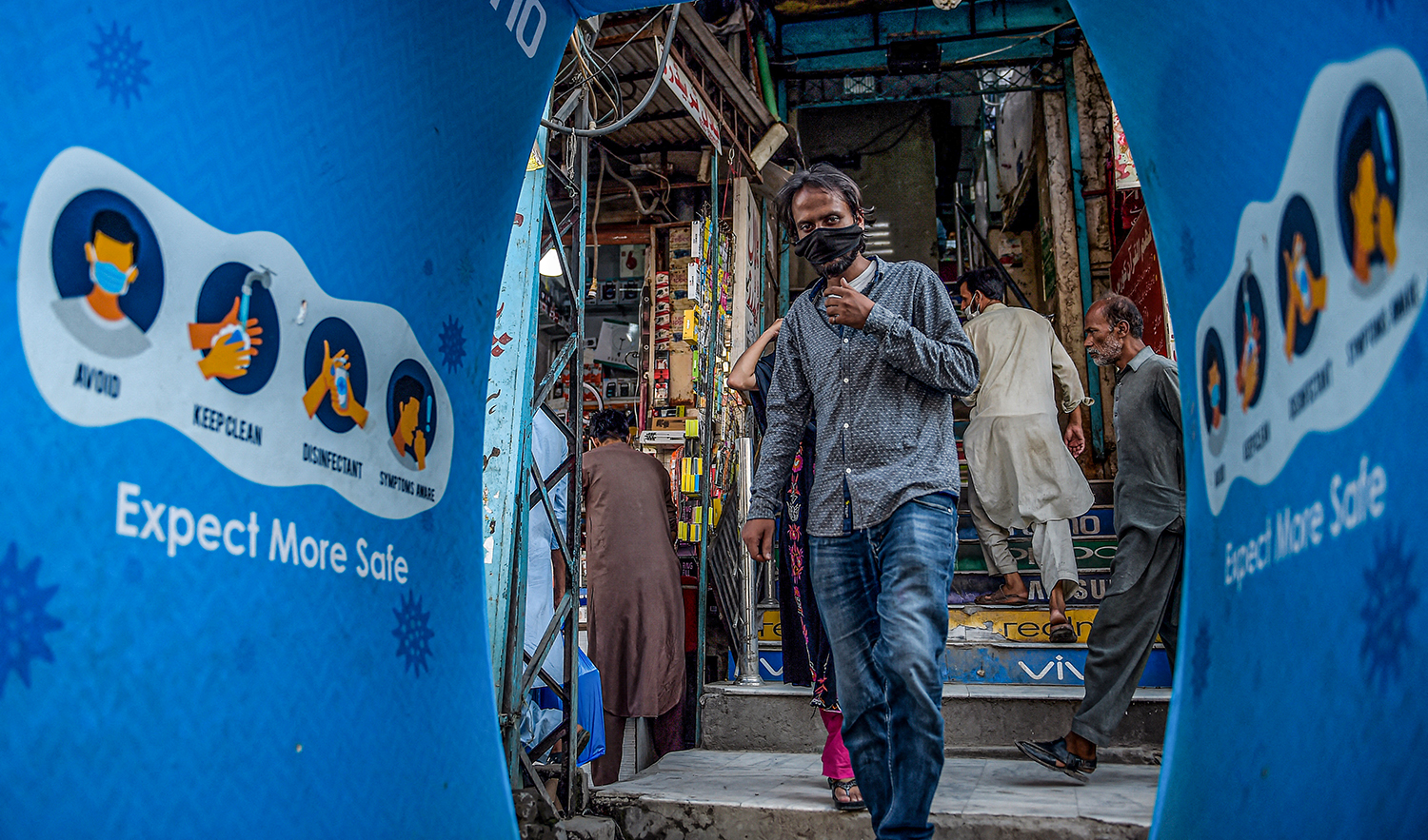 A man wearing a face mask as a preventive measure against the COVID-19 coronavirus enters a disinfection tunnel at the Raja Bazar in Rawalpindi on July 22, 2020. (AFP/File)