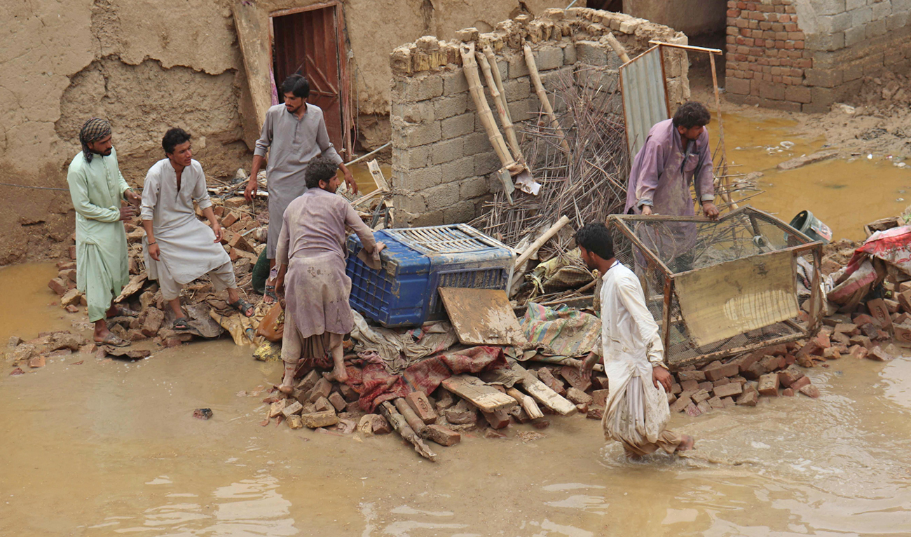 Residents clear debris of a damaged house due to a heavy monsoon rainfall on the outskirts of Quetta, Pakistan on July 5, 2022. (AFP)