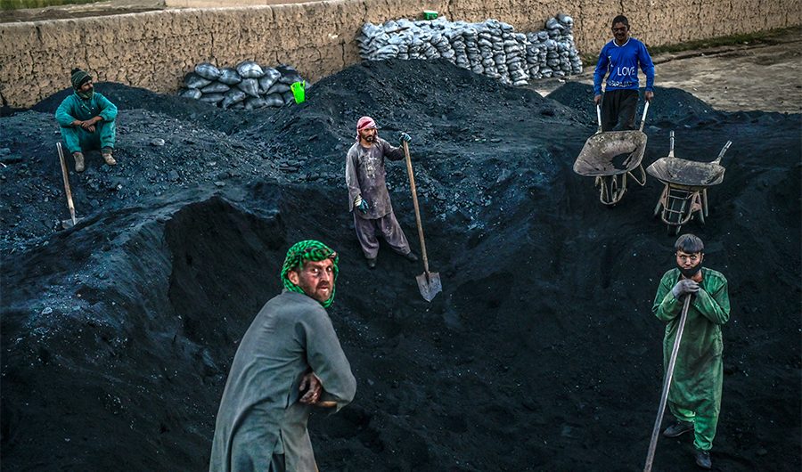 Hazara workers prepare to load coal onto a truck in Bamiyan province on October 3, 2021. (AFP/FILE)
