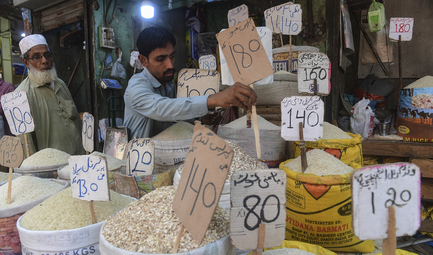 A shopkeeper place a price tag on rice at a shop in Karachi, Pakistan, on June 10, 2022. (AFP/File)