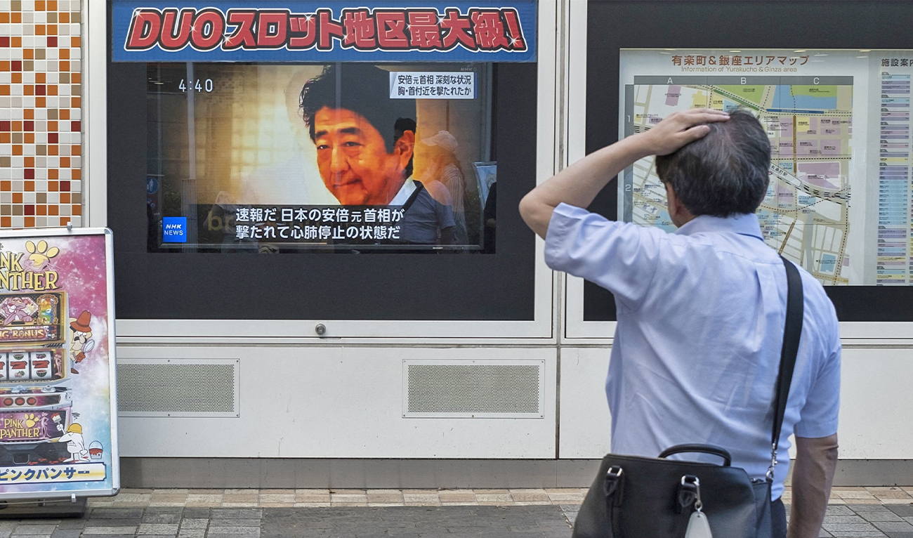 A man looks at a television broadcast showing news about the attack on former Japanese prime minister Shinzo Abe earlier in the day, along a street of Tokyo, Japan, on July 8, 2022. (AFP)
